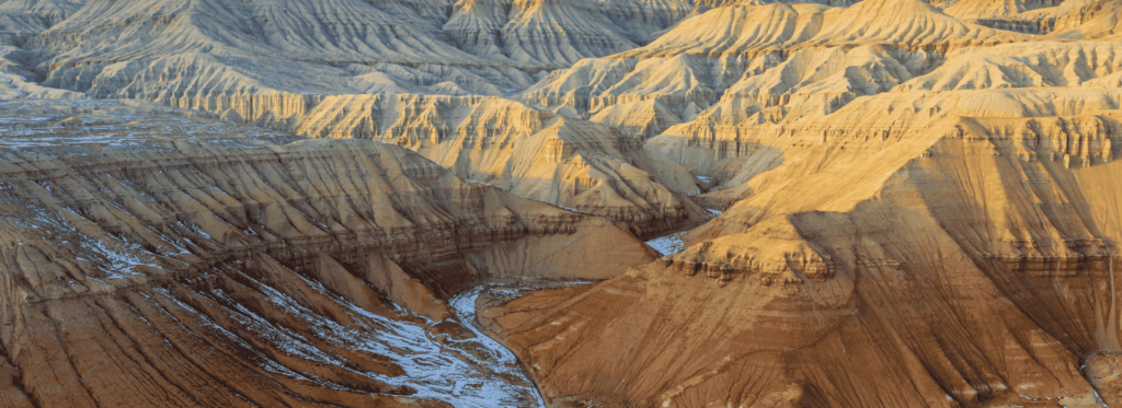 1. A panoramic view of the rugged Badlands in Arizona, showcasing unique rock formations and arid landscapes under a clear sky. 2. The striking Badlands of Arizona, featuring dramatic cliffs and colorful geological formations in a vast, arid environment. 3. A scenic depiction of Arizona's Badlands, highlighting the intricate patterns of erosion and vibrant colors of the desert terrain.