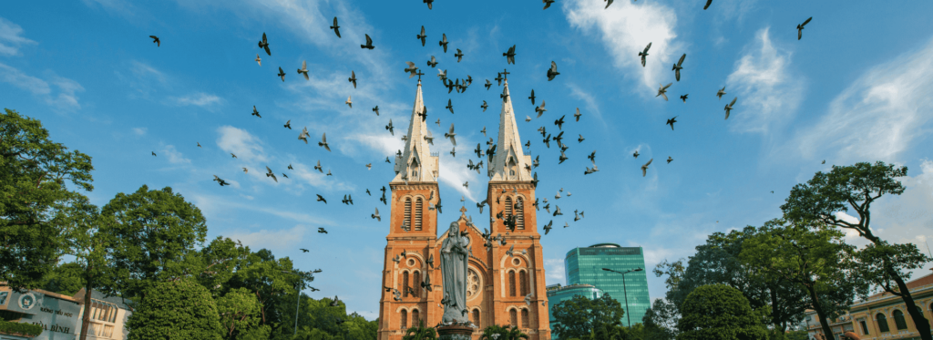A majestic cathedral surrounded by birds soaring gracefully in the sky.