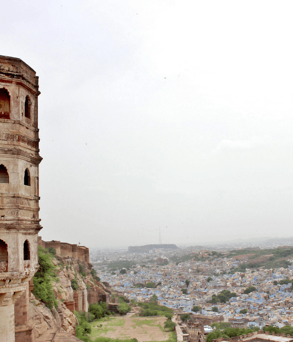 a building on a cliff with a city in the background
