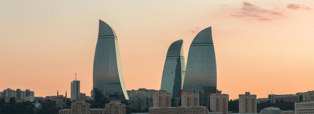 Baku, Azerbaijan skyline featuring modern architecture and the Caspian Sea in the background.
