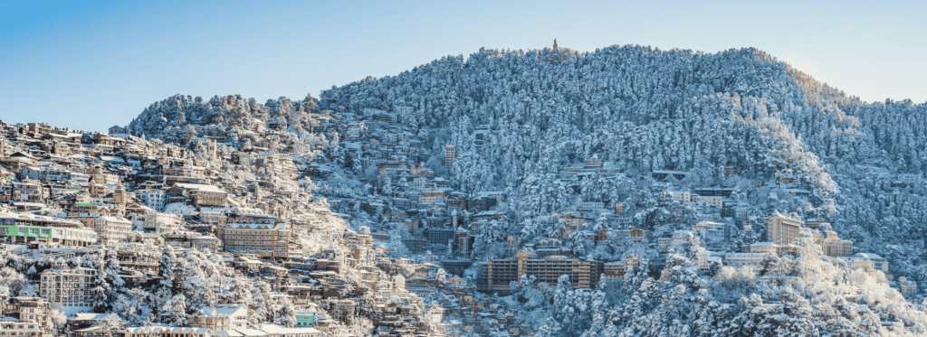 A snowy mountain adorned with trees and buildings, showcasing a serene winter landscape