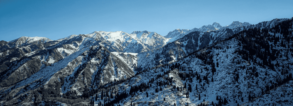 Snow-covered mountains in the Kashmir region, showcasing a serene winter landscape with majestic peaks and pristine white slopes.