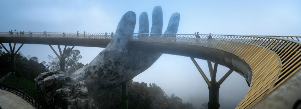 A hand reaches out from a bridge, representing a gesture of connection and exploration into the distance.