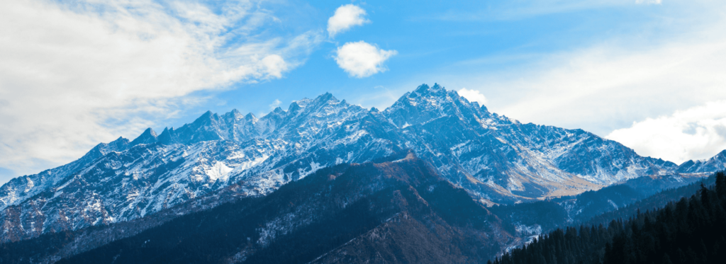 Scenic view of a mountain range with stunning snow-covered peaks against a vibrant sky.