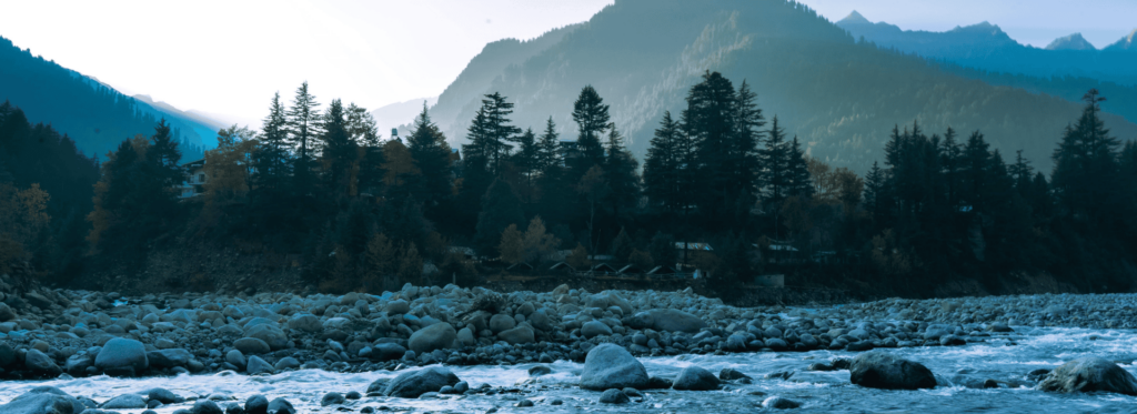 A serene river meanders through a majestic mountain range, surrounded by rocks and lush trees.