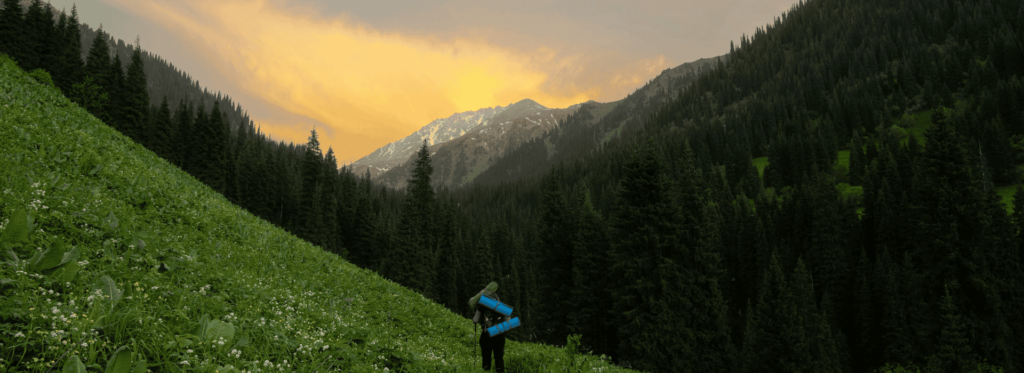 a person walking on a hill with a large backpack