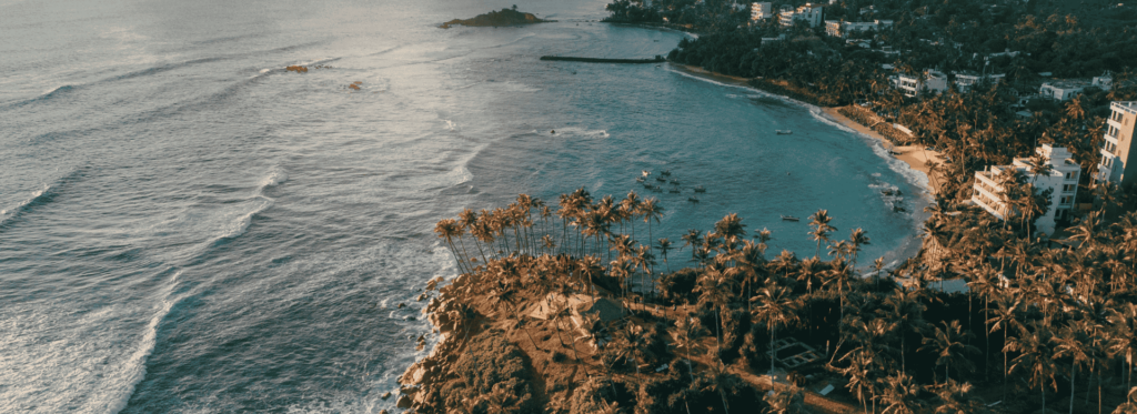 Aerial image depicting a serene beach alongside the ocean, emphasizing the contrast between sand and water.